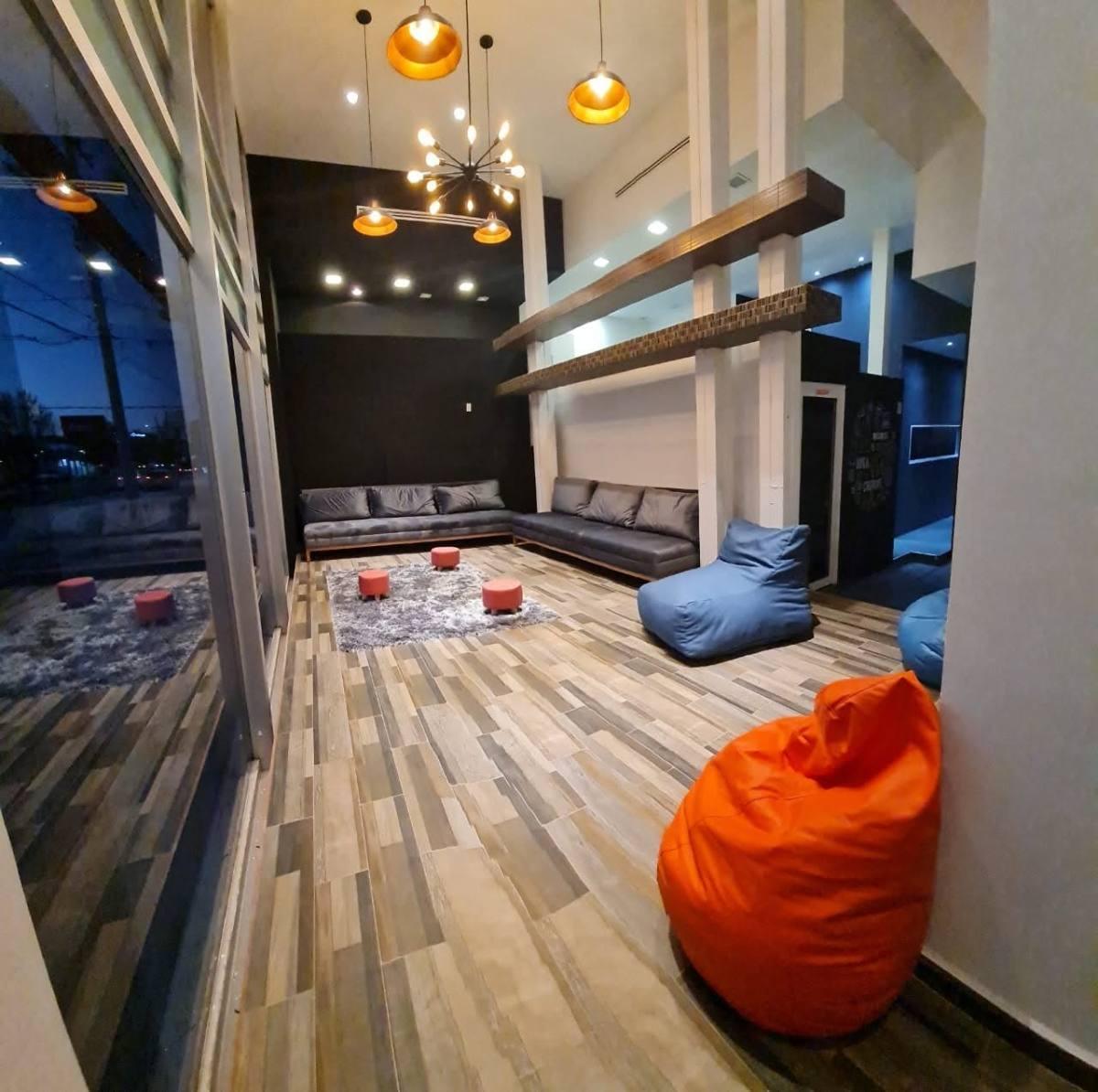 Lounge de D4 Business Center con sillones, puffs y luz cálida